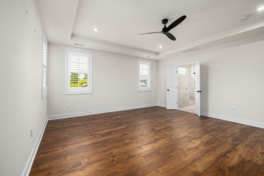 An empty bedroom with clean wooden flooring ready for a property handover